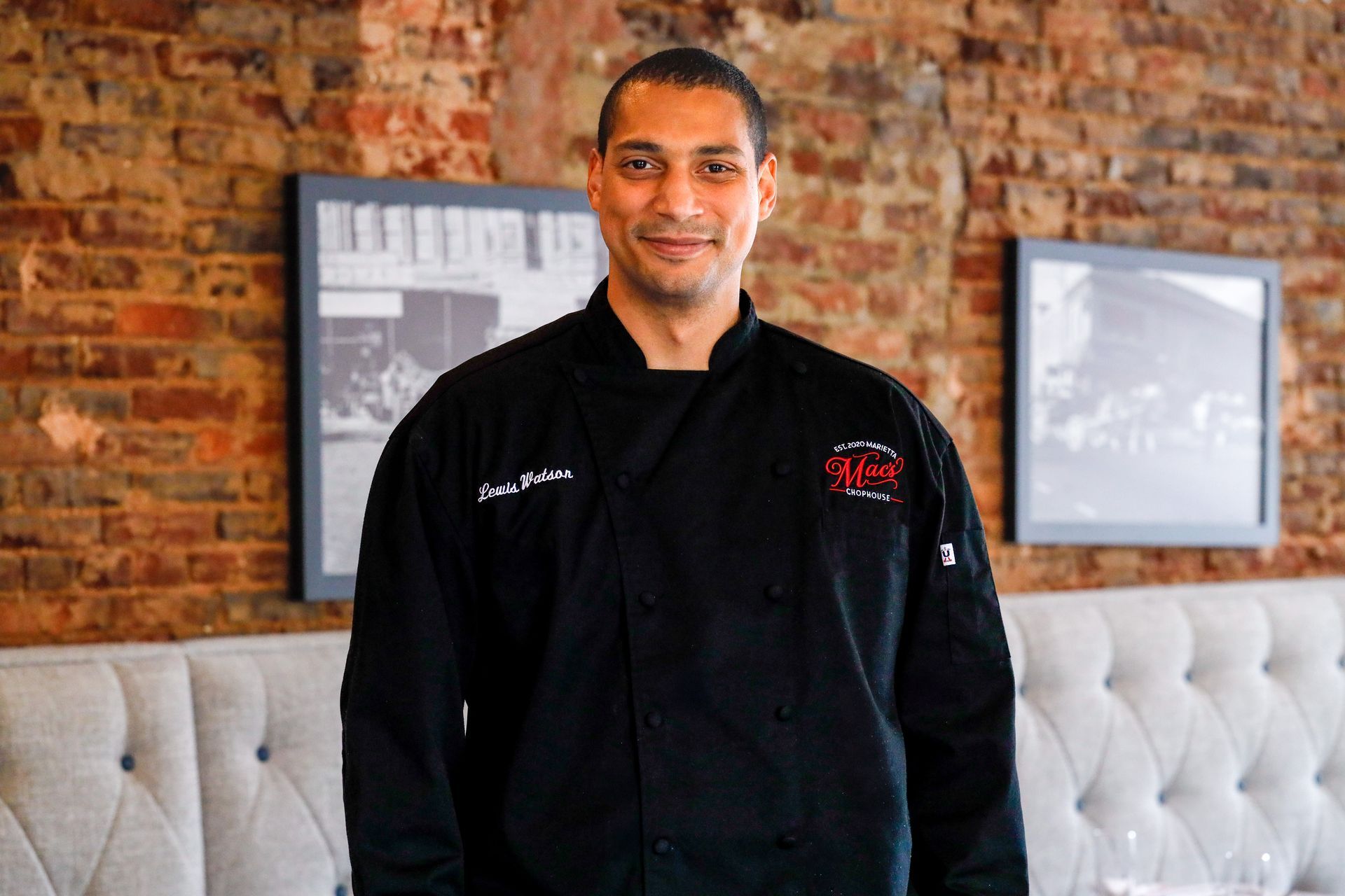 A woman is sitting at a table holding a plate of food.