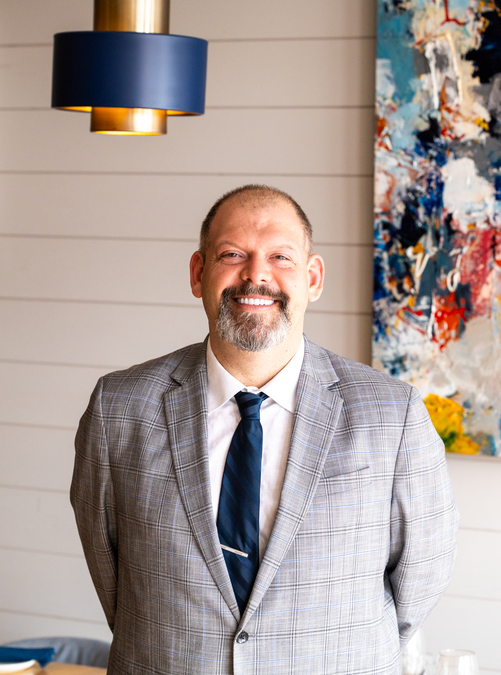 A woman is sitting at a table holding a plate of food.