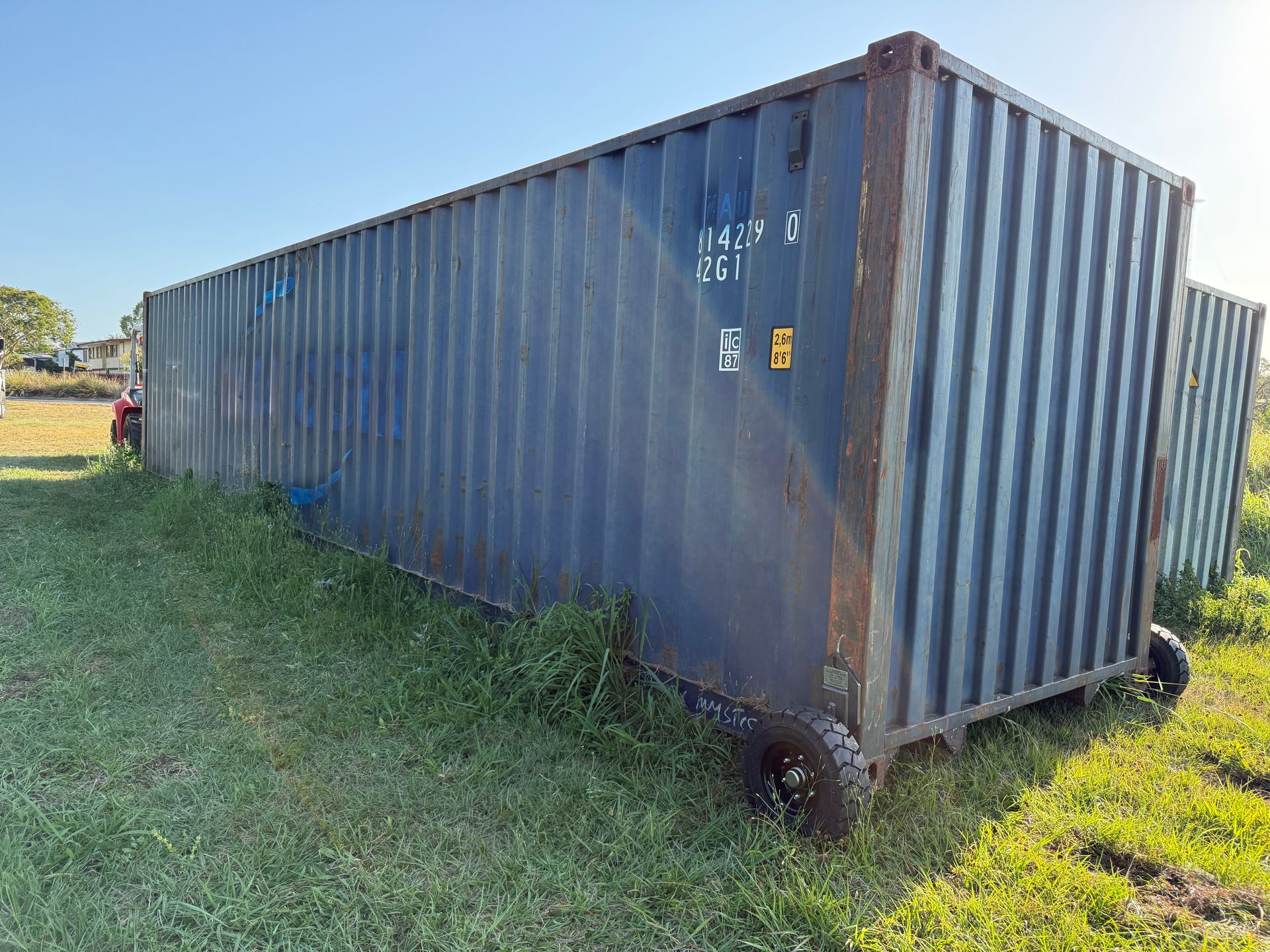 Blue shipping container on wheels in grassy field. — Supertilt Brisbane In Bracken Ridge, QLD