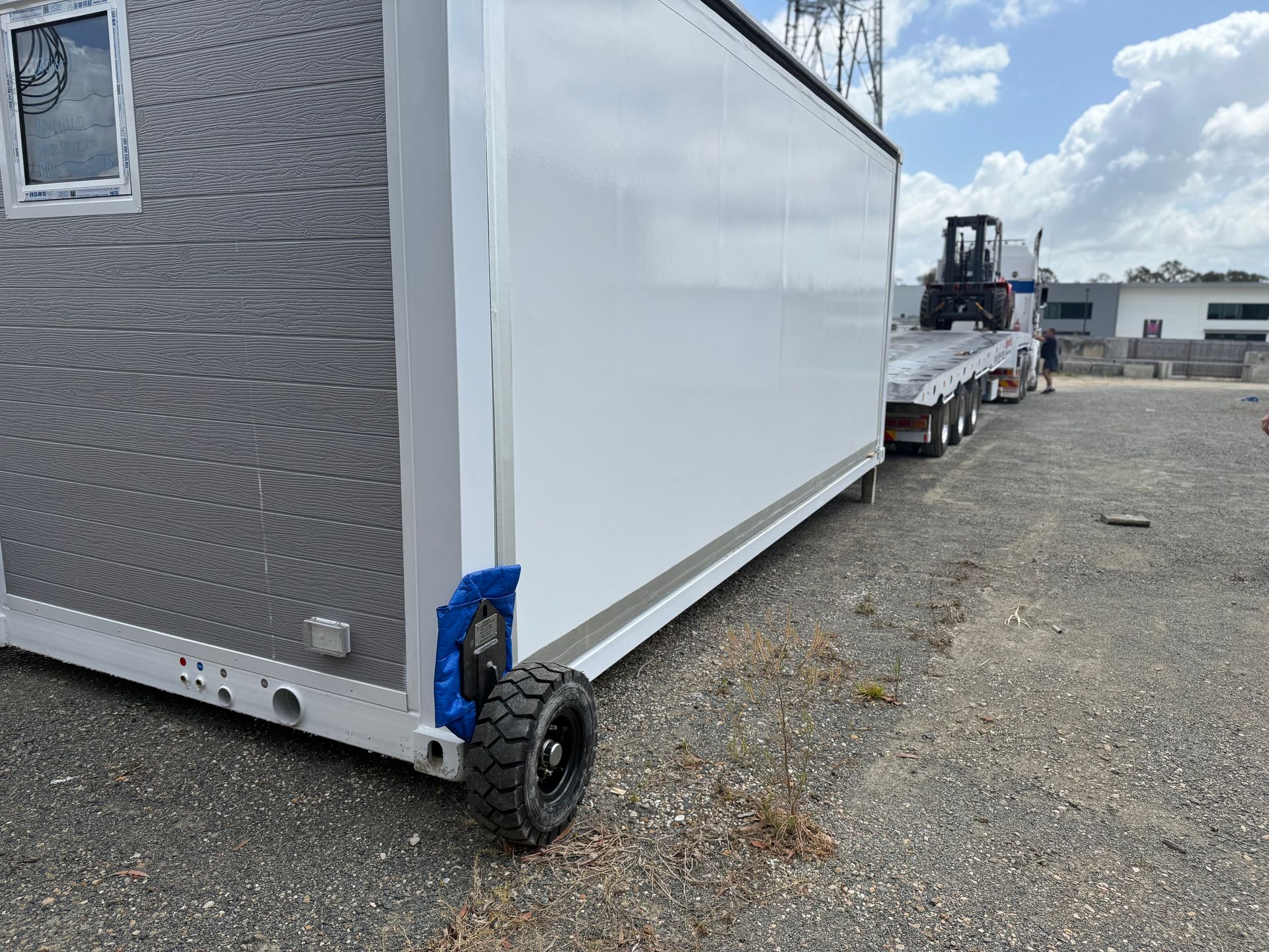 A Long, White Modular Building Being Transported on a Flatbed Truck — Supertilt Brisbane In Bracken Ridge, QLD