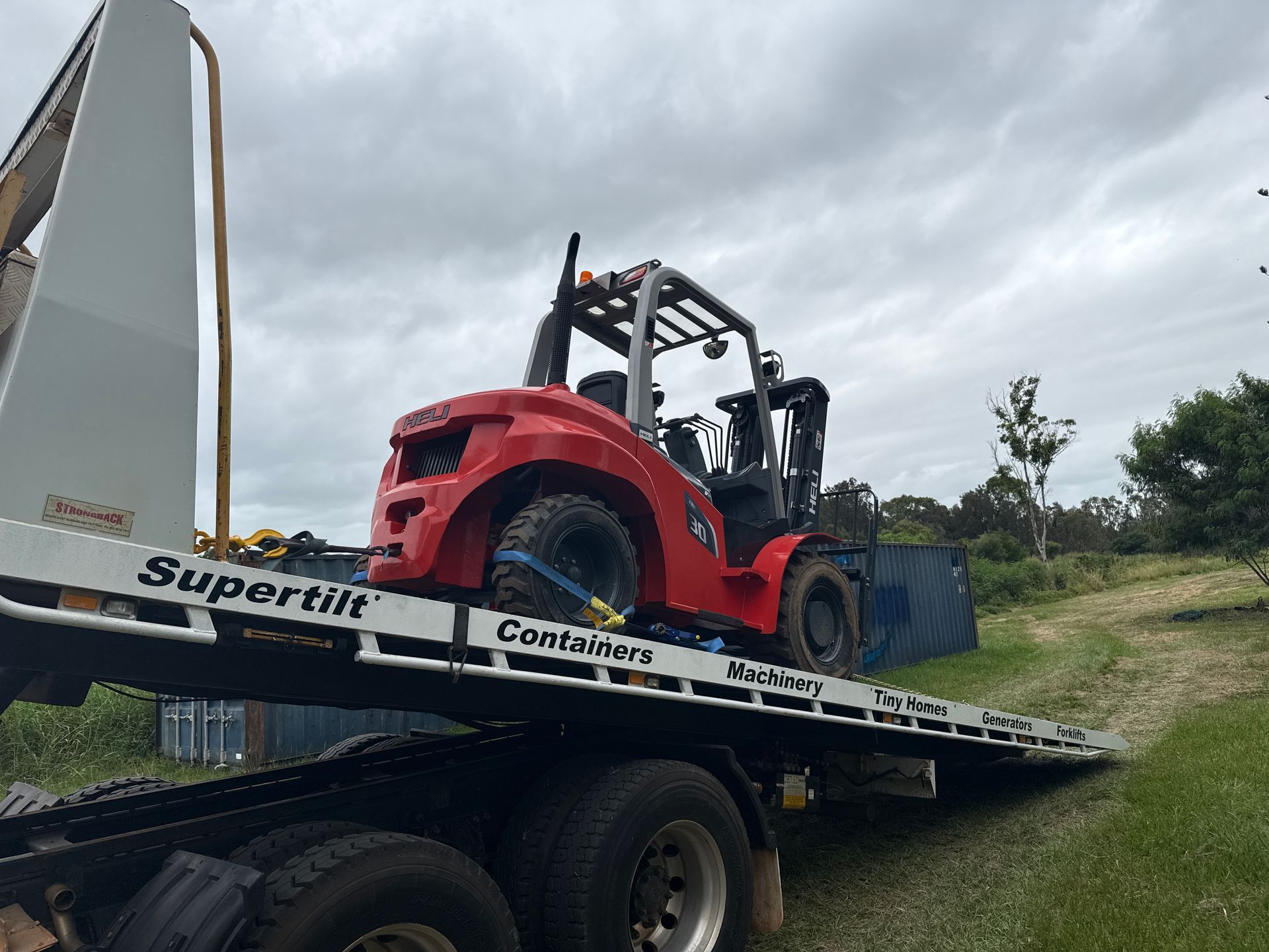 White and Blue Semi-truck With a Flatbed Trailer Parked on Grass — Supertilt Brisbane In Bracken Ridge, QLD