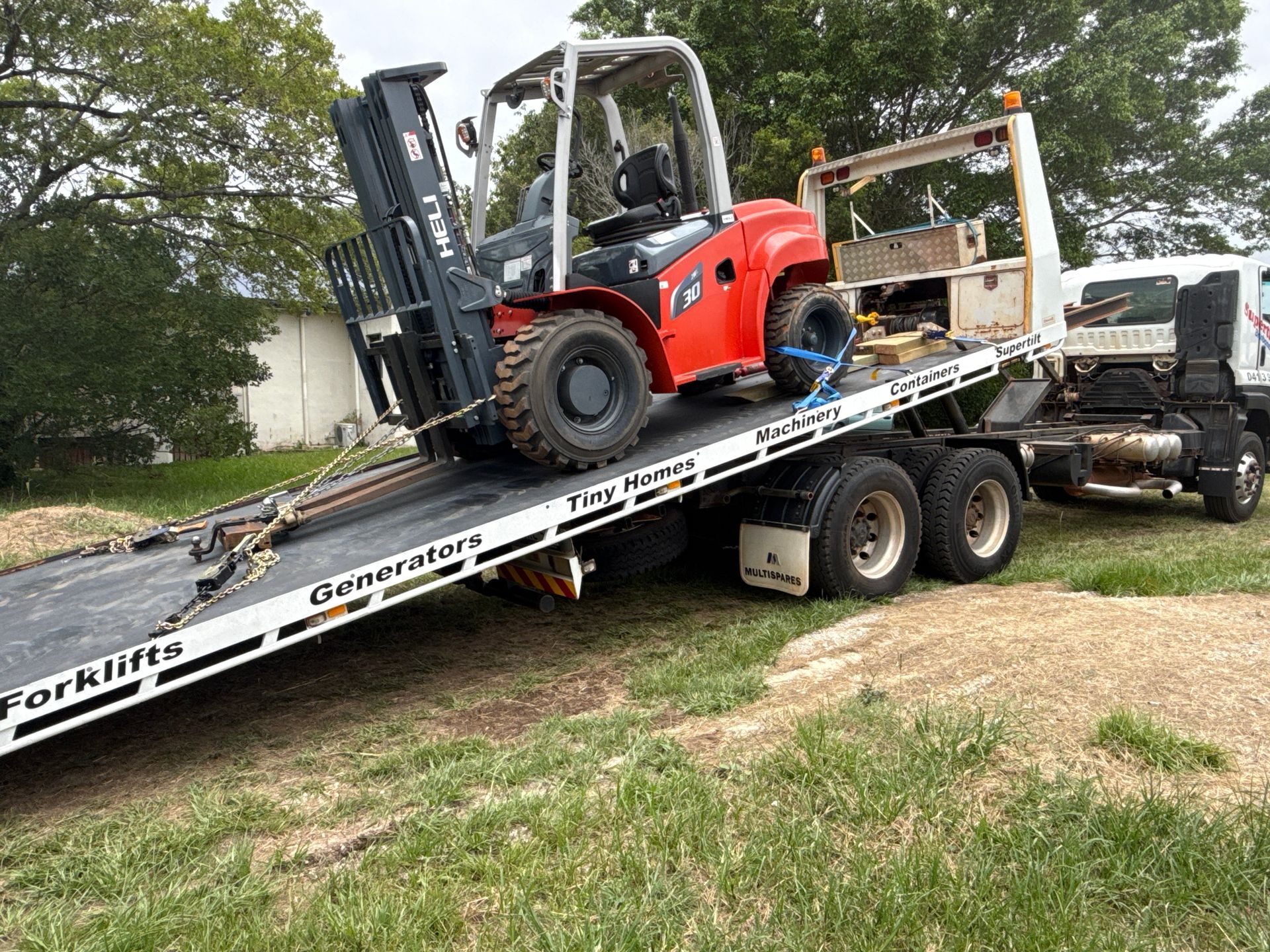 A White Pickup Truck on a Tow Truck is Parked in Front of Houses and Trees — Supertilt Brisbane In Bracken Ridge, QLD