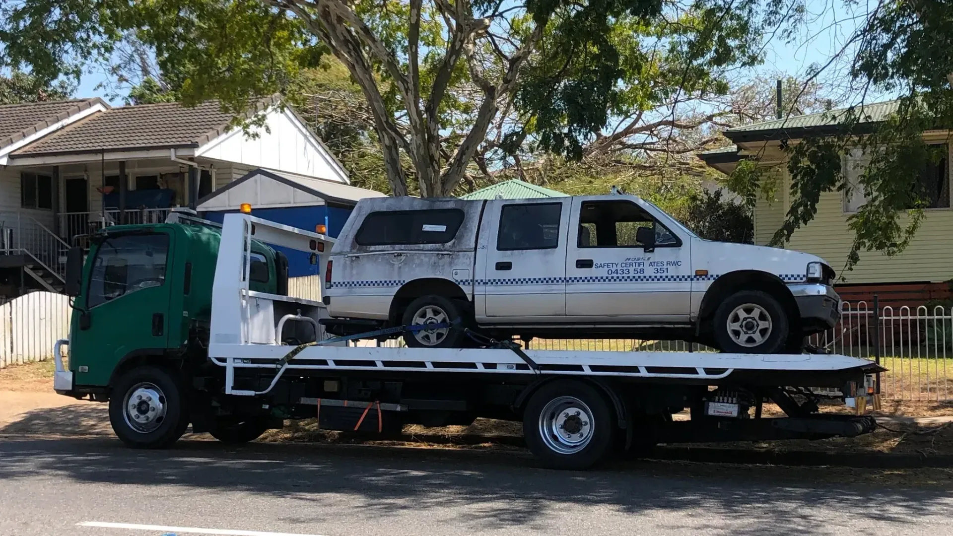 A White Pickup Truck on a Tow Truck is Parked in Front of Houses and Trees — Supertilt Brisbane In Bracken Ridge, QLD