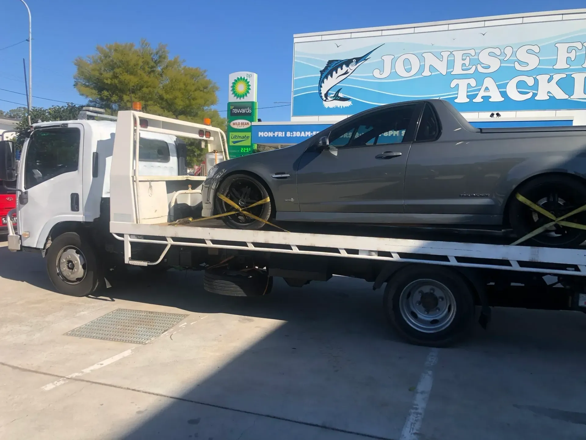 A Grey Car Being Towed on a Flatbed Truck at a Gas Station —Supertilt Brisbane In Bracken Ridge, QLD
