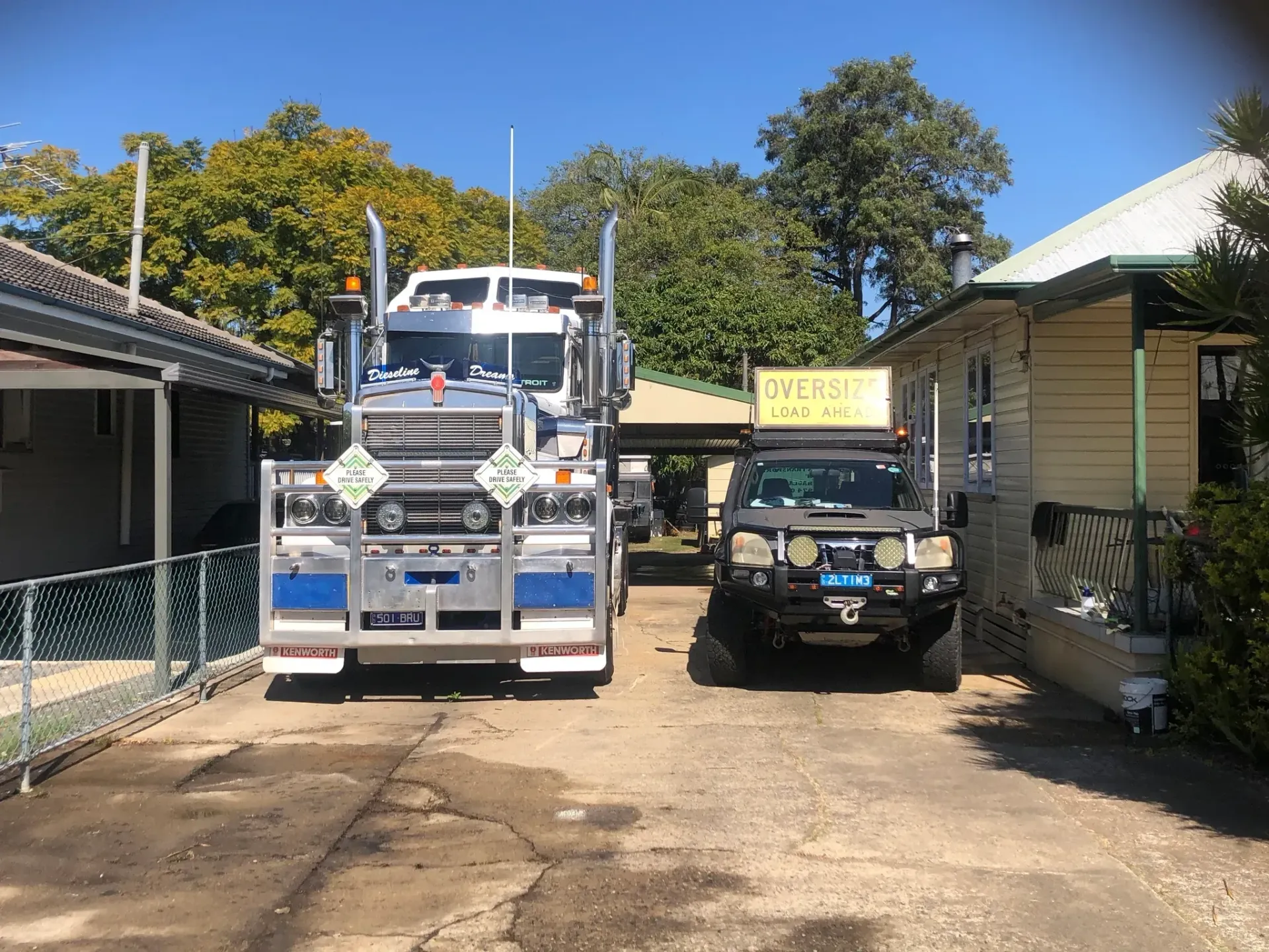 A Large Semi-truck and a Smaller SUV Parked in a Narrow Driveway — — Supertilt Brisbane In Archerfield, QLD
