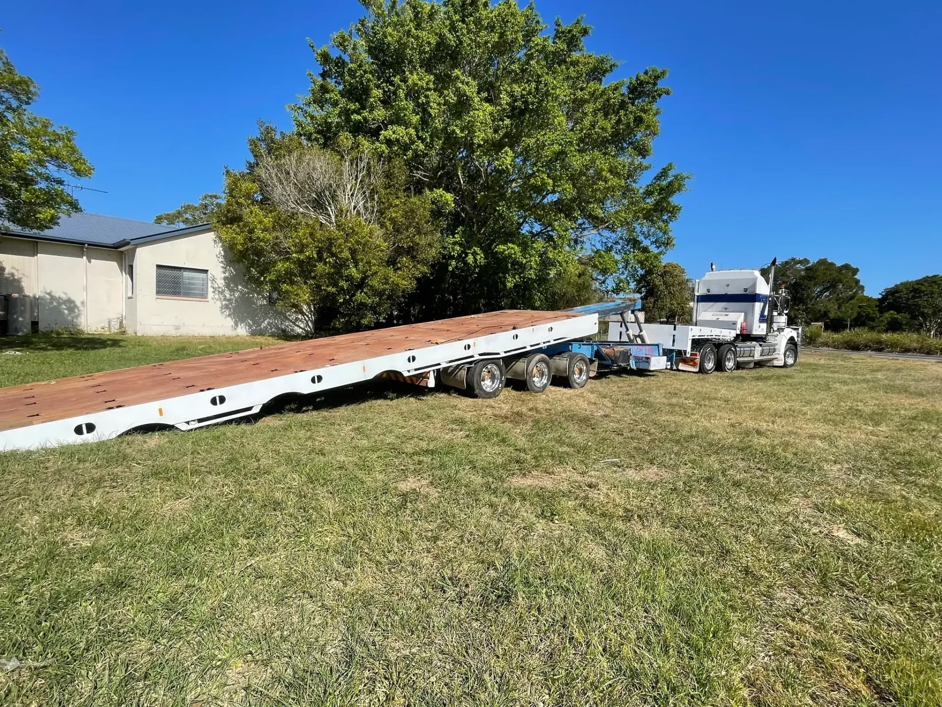 A Long-bed Semi-truck Parked Next to a Small Building — Supertilt Brisbane In Yatala, QLD
