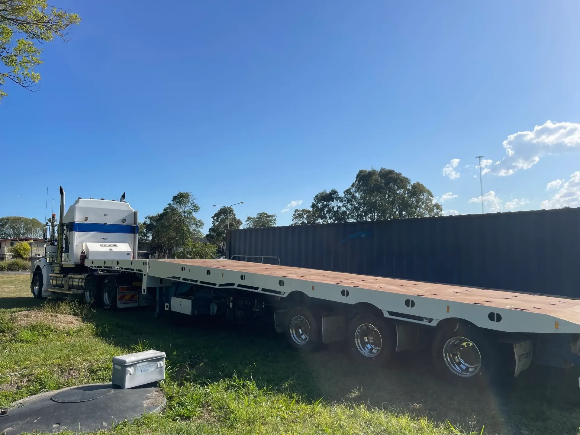 Truck With a Flatbed Trailer Parked on Grass — Supertilt Brisbane In Staplyton, QLD