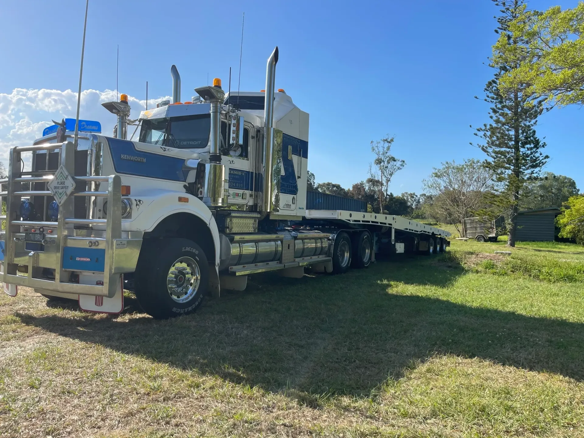 White and Blue Semi-truck With a Flatbed Trailer Parked on Grass — Supertilt Brisbane In Bracken Ridge, QLD