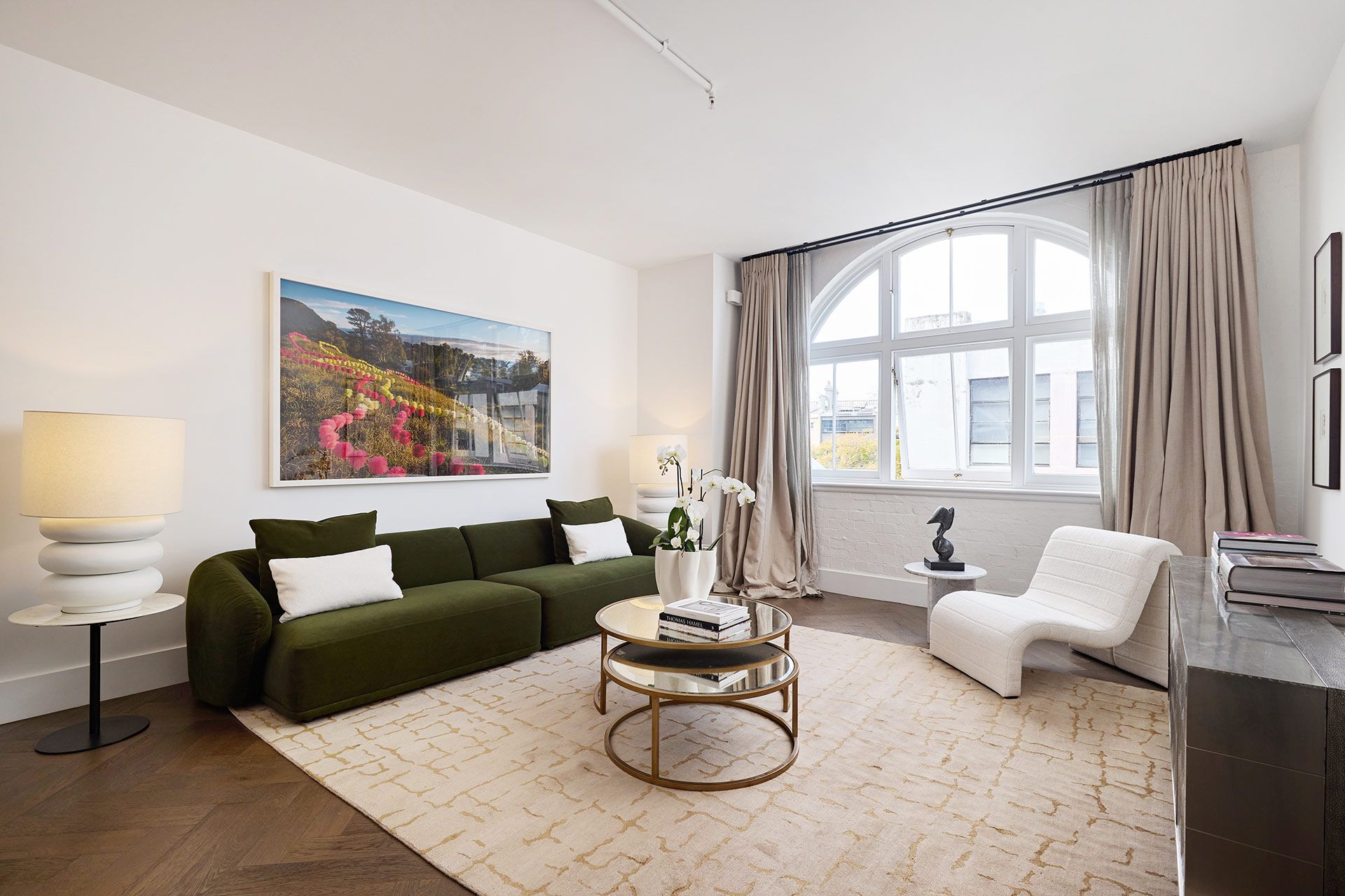 A living room with a green couch and a white chair.