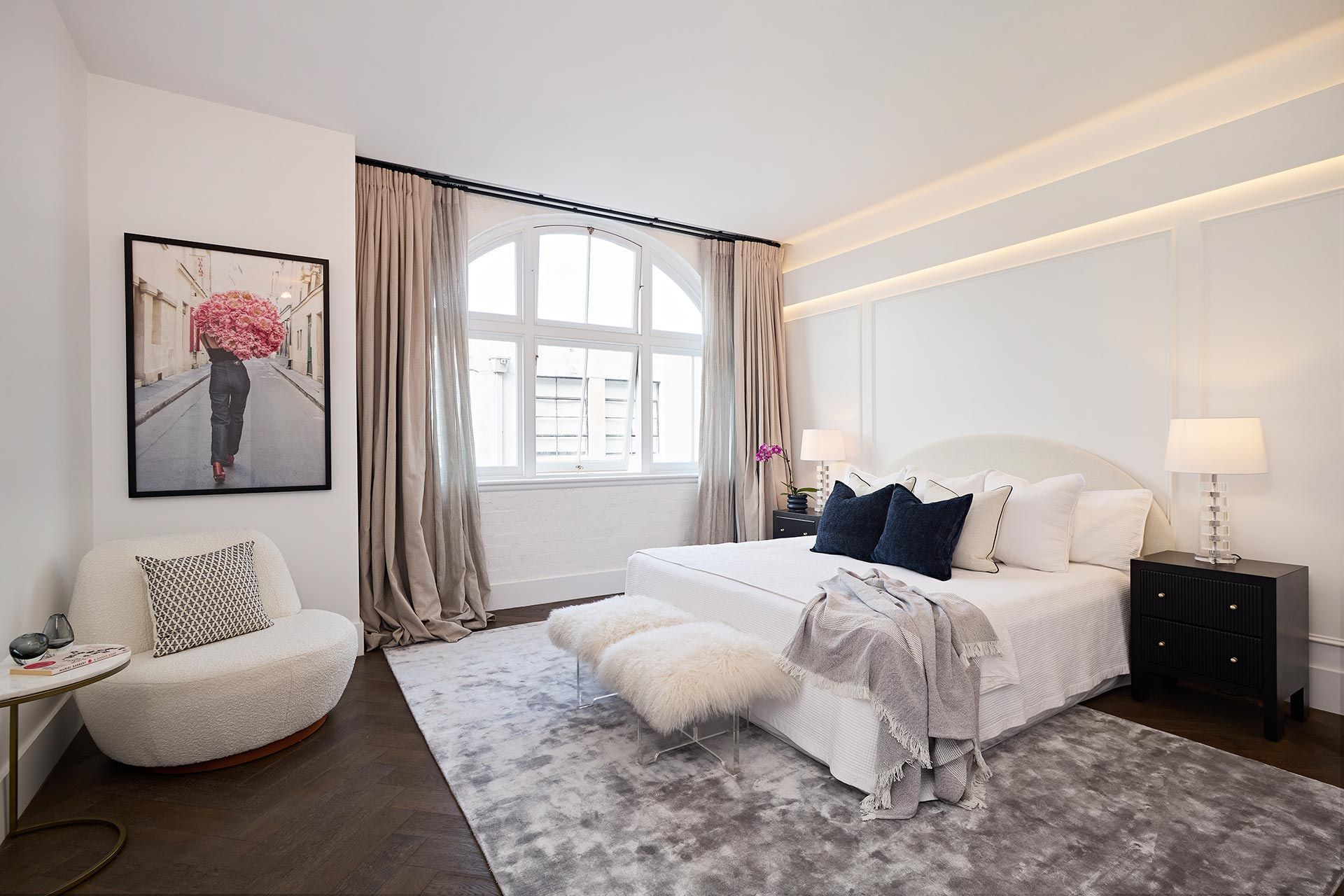 A bedroom with a large bed and a chair. Beauty Point.