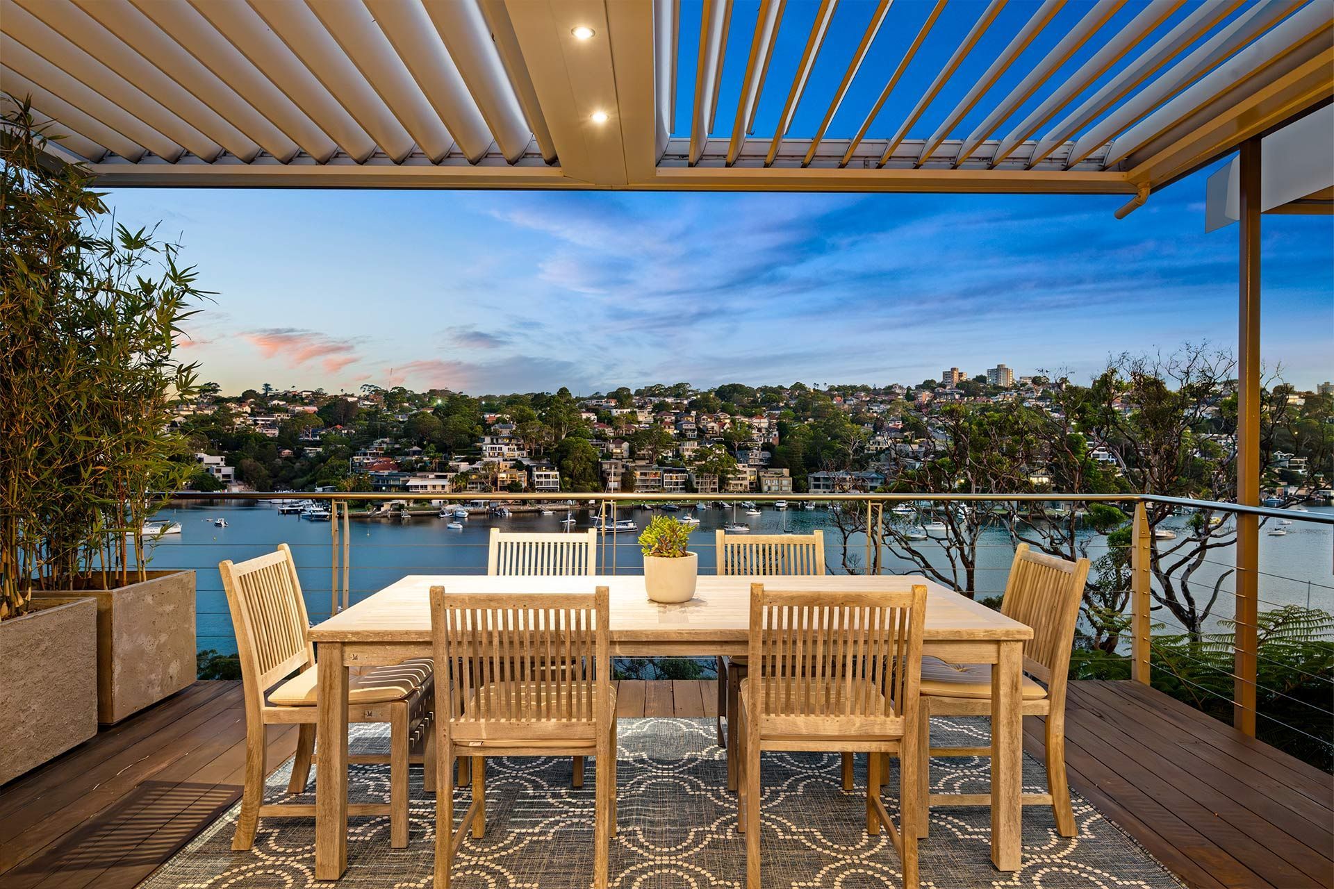 A patio with a table and chairs overlooking a body of water