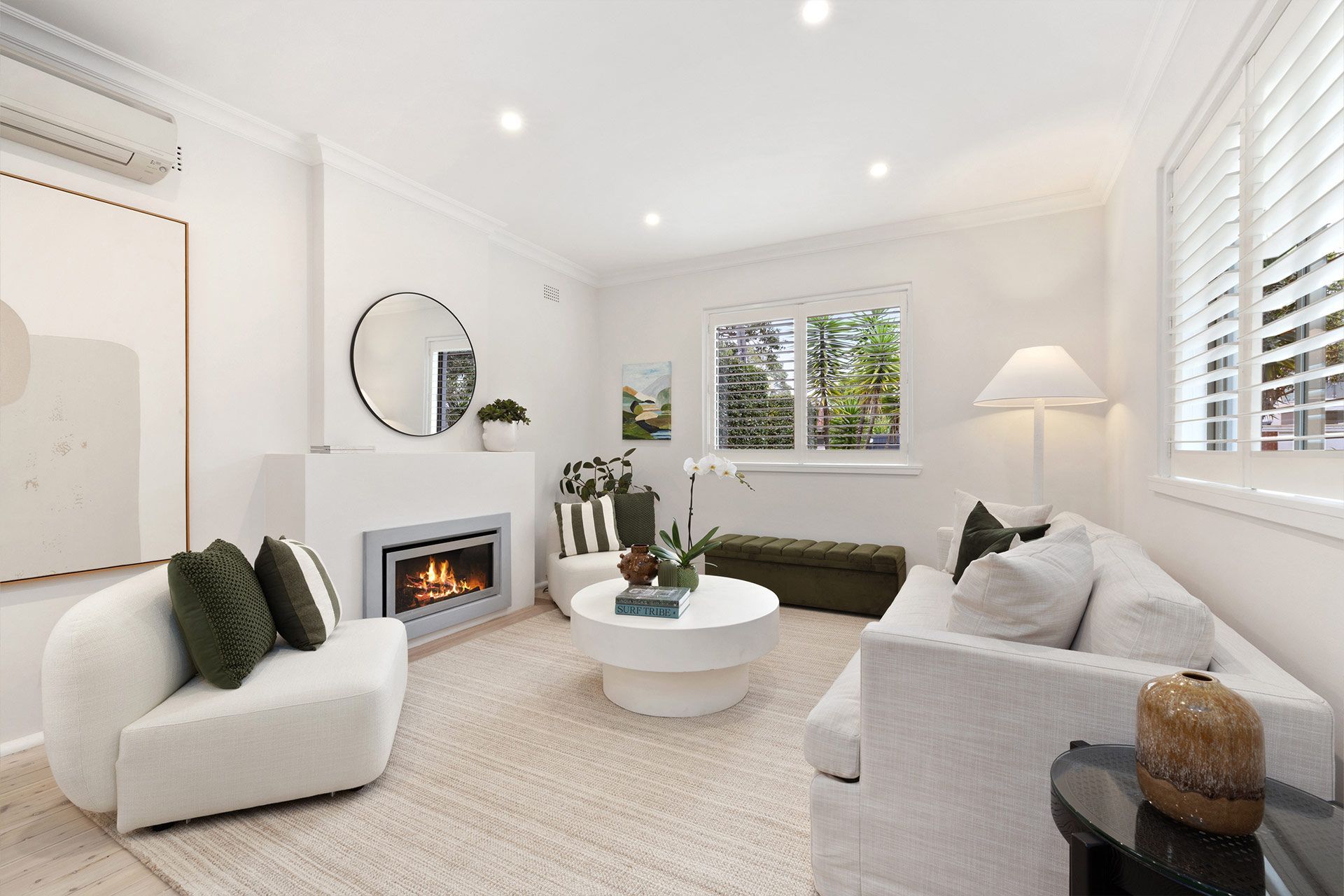 A living room with a couch , chair , coffee table and fireplace.