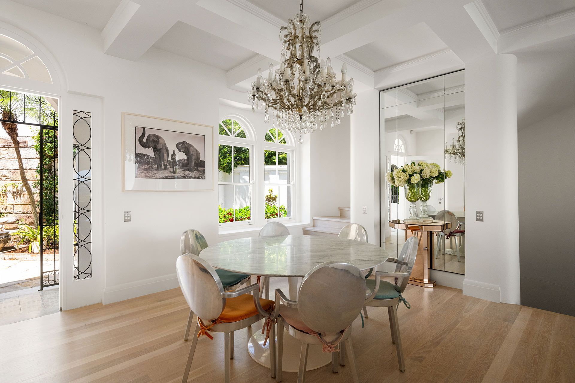 A dining room with a table and chairs and a chandelier. Cremorne