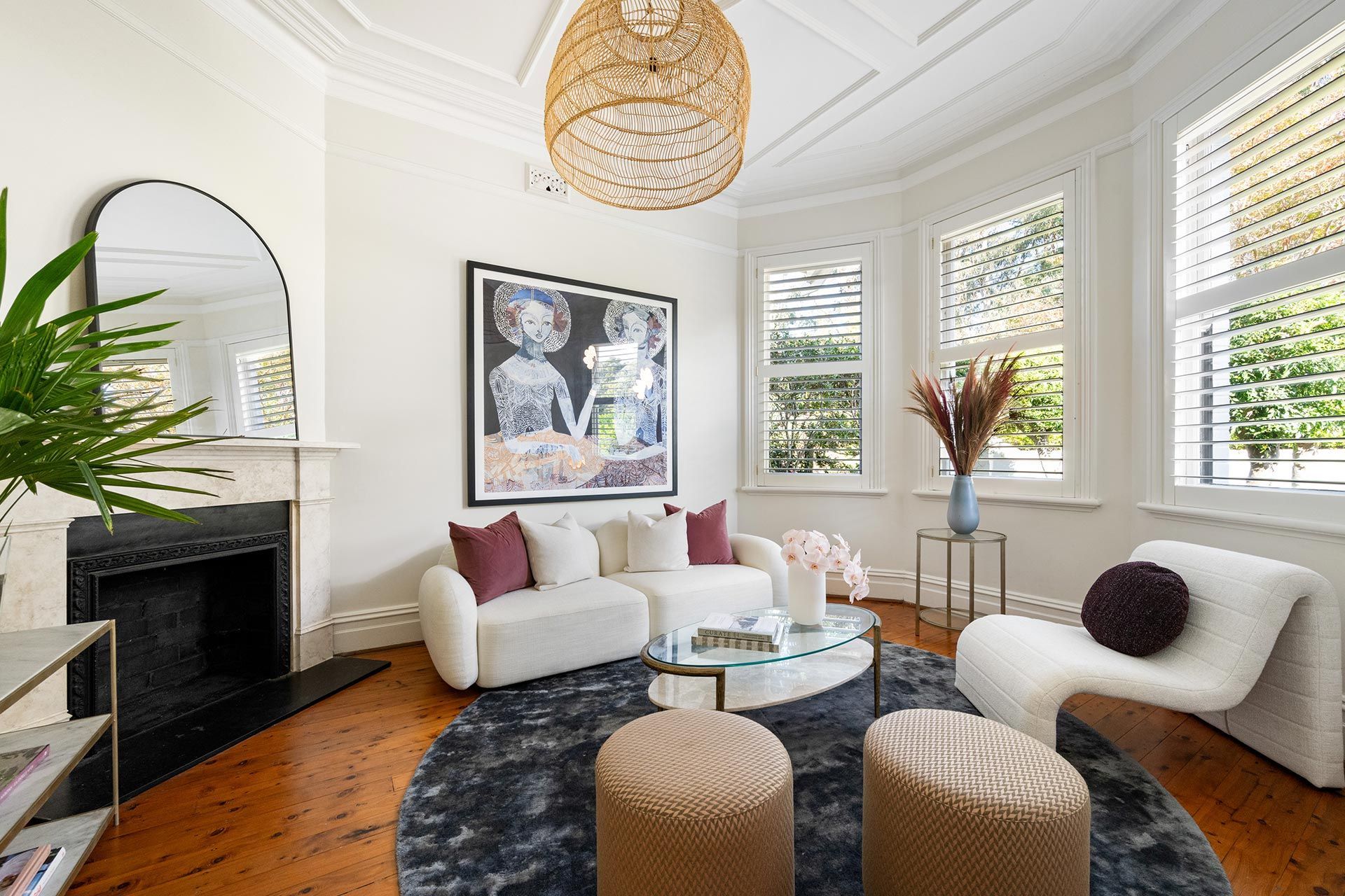 A living room with a couch , chair , coffee table and fireplace.