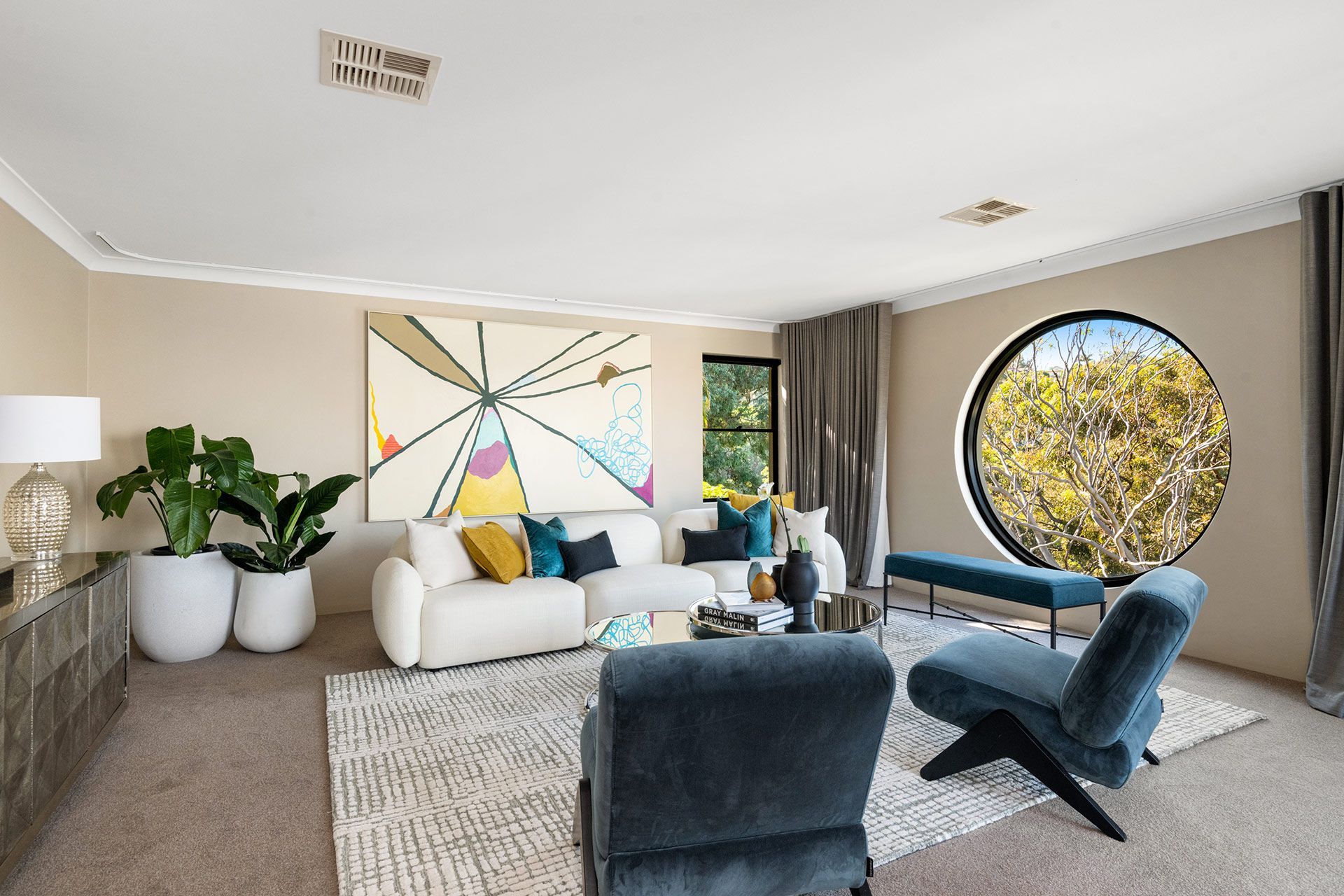 A living room with a couch , chairs , and a round window. Balmoral, Mosman.