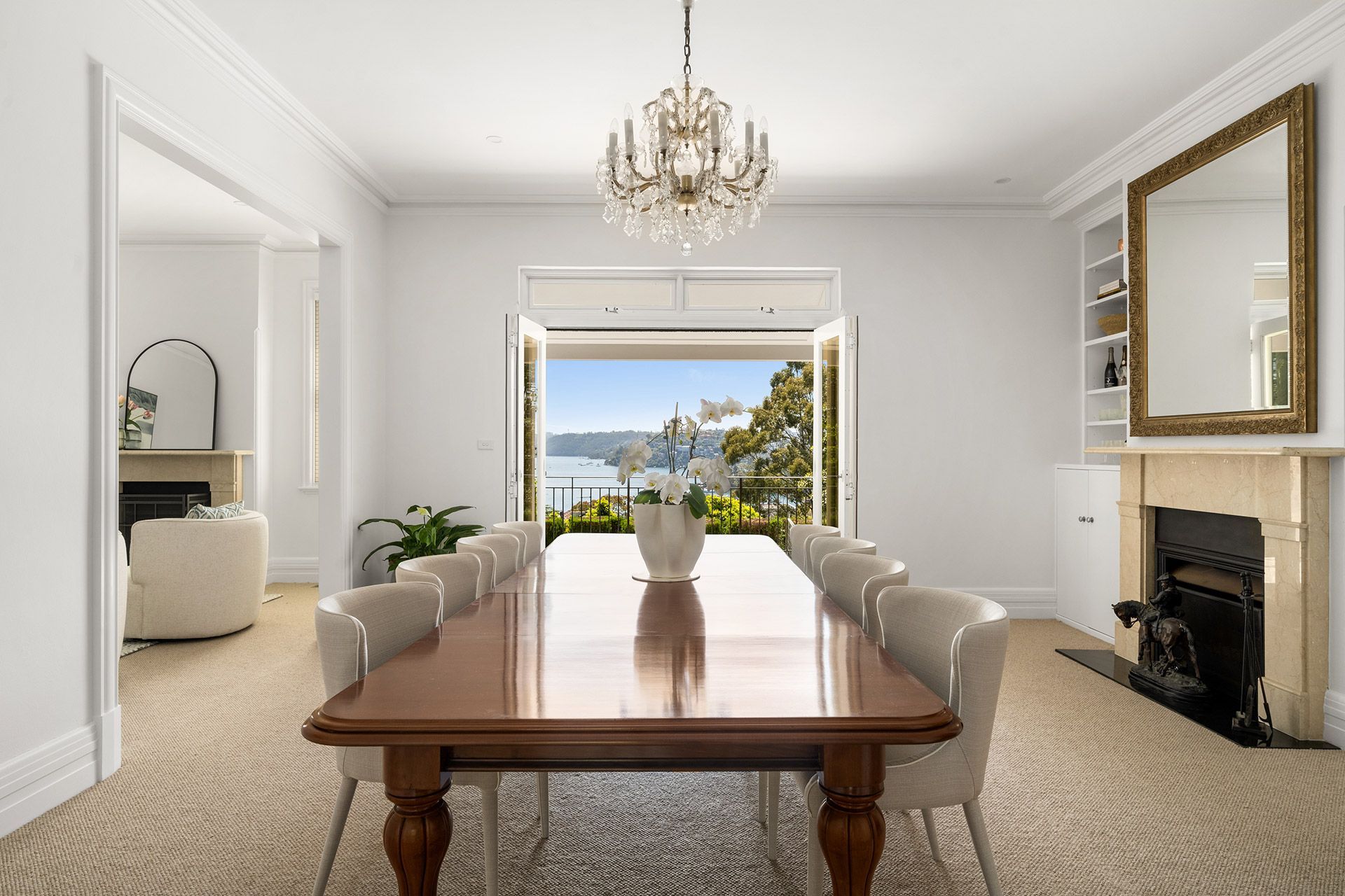 A dining room with a long table and chairs and a fireplace.