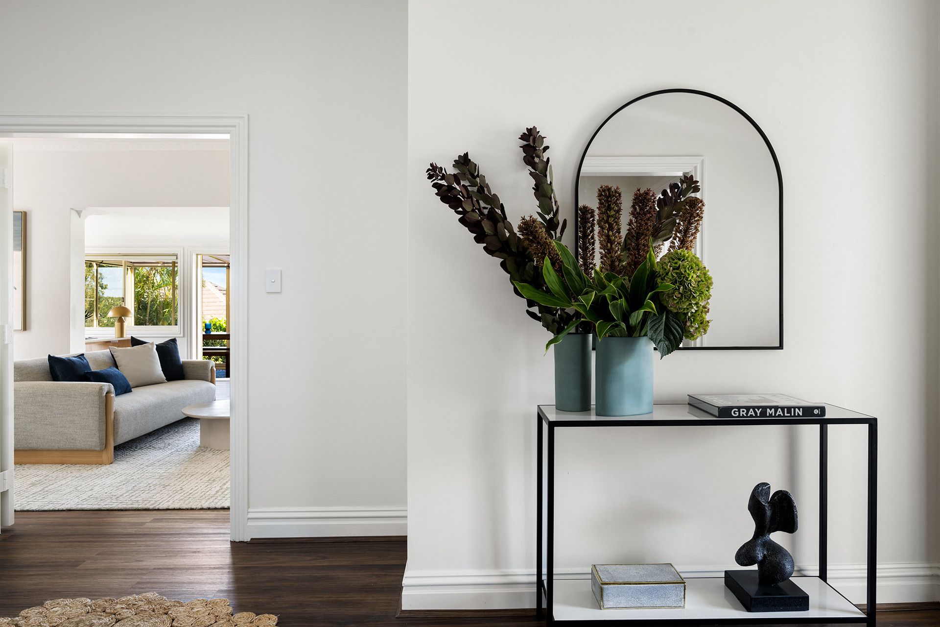 A living room with a couch and a table with a vase of flowers on it. Balmoral
