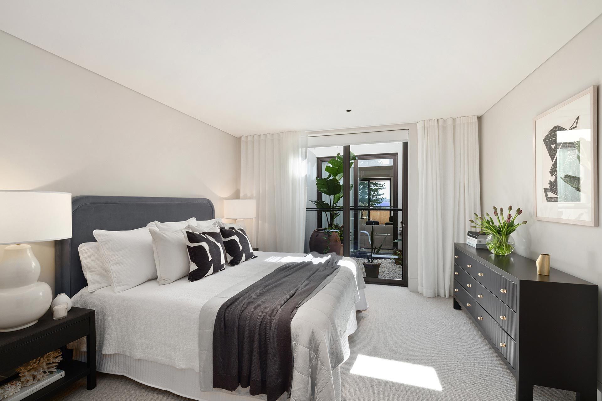 A bedroom with a large bed and a dresser