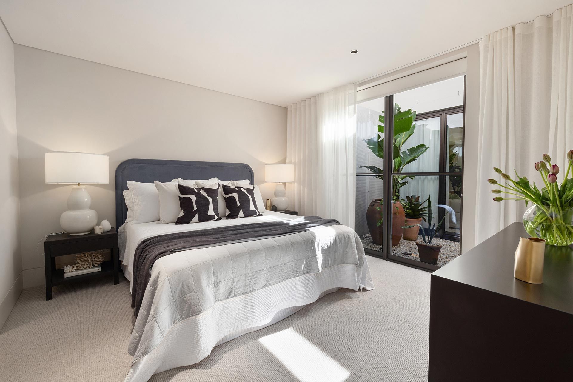 A bedroom with a large bed and a balcony.