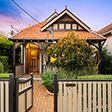 A small house with a wooden fence in front of it.