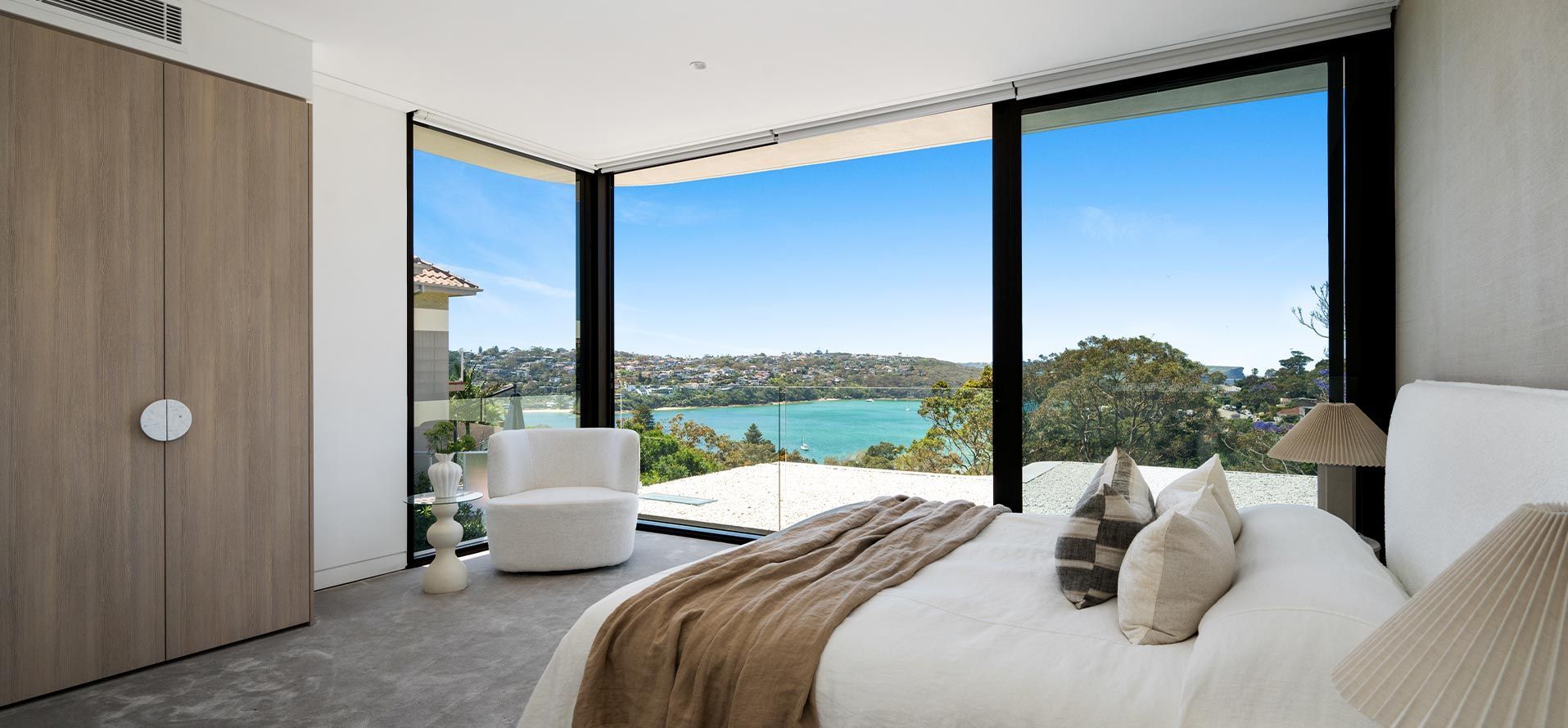 A bedroom with a large bed and a view of a lake.