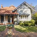 A large house with a brick driveway and a statue in front of it. Freshwater.