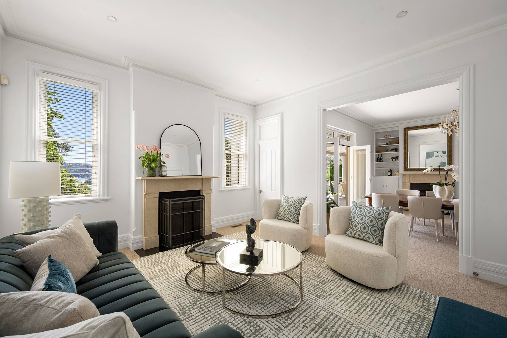 A living room with a couch , chairs , coffee table and fireplace.