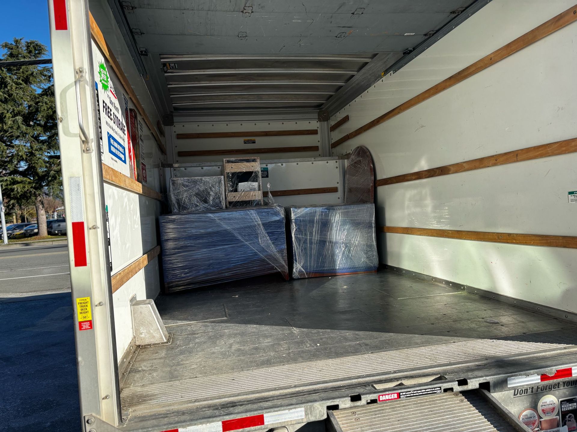 A man is standing in the back of a moving truck.
