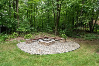 clean looking  modern fire pit with bench seating over river gravel