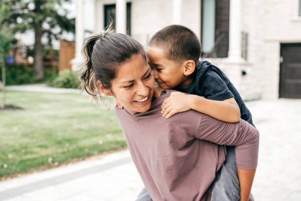 A woman is carrying a child on her back.