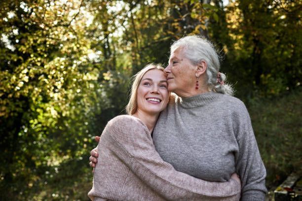 An older woman is kissing a younger woman on the cheek.
