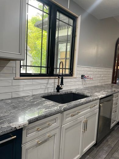 Hallway under construction with white walls, doors, and exposed ceiling.
