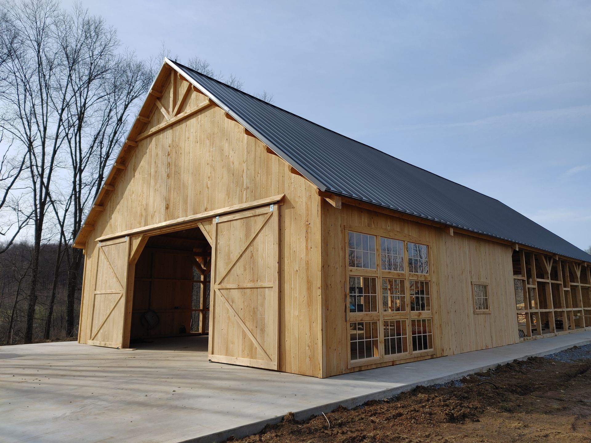 A new wooden barn with a dark metal roof, sliding doors in Central Pennsylvania. 