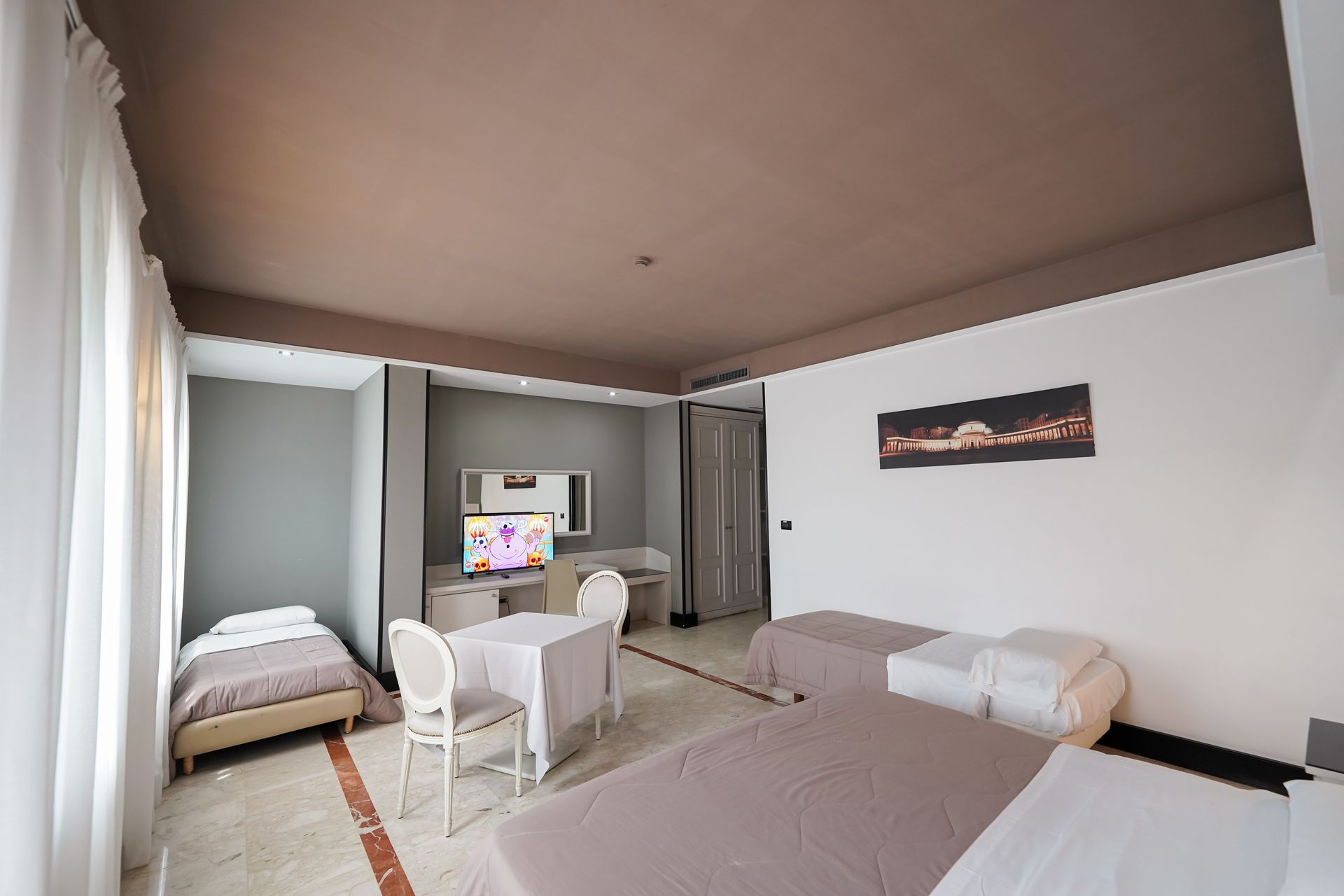 Camera da letto essenziale con due letti, sedie bianche, TV e soffitto marrone in una stanza moderna