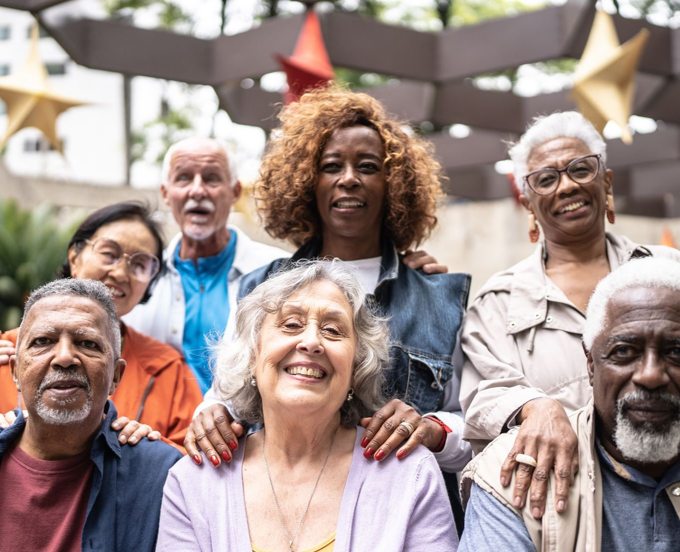 Group of diverse seniors smiling outdoors.