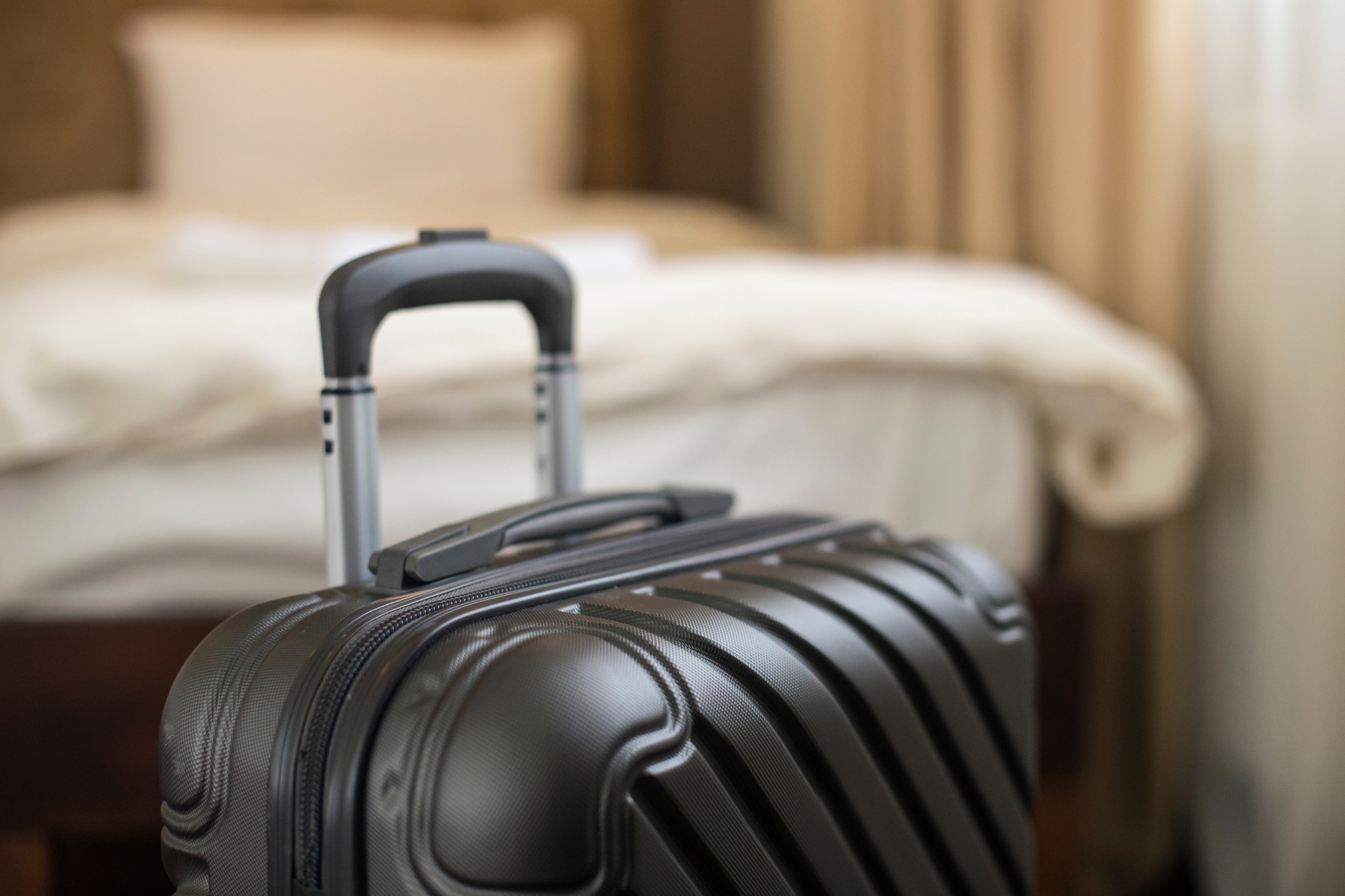 A suitcase is sitting in a hotel room next to a bed.