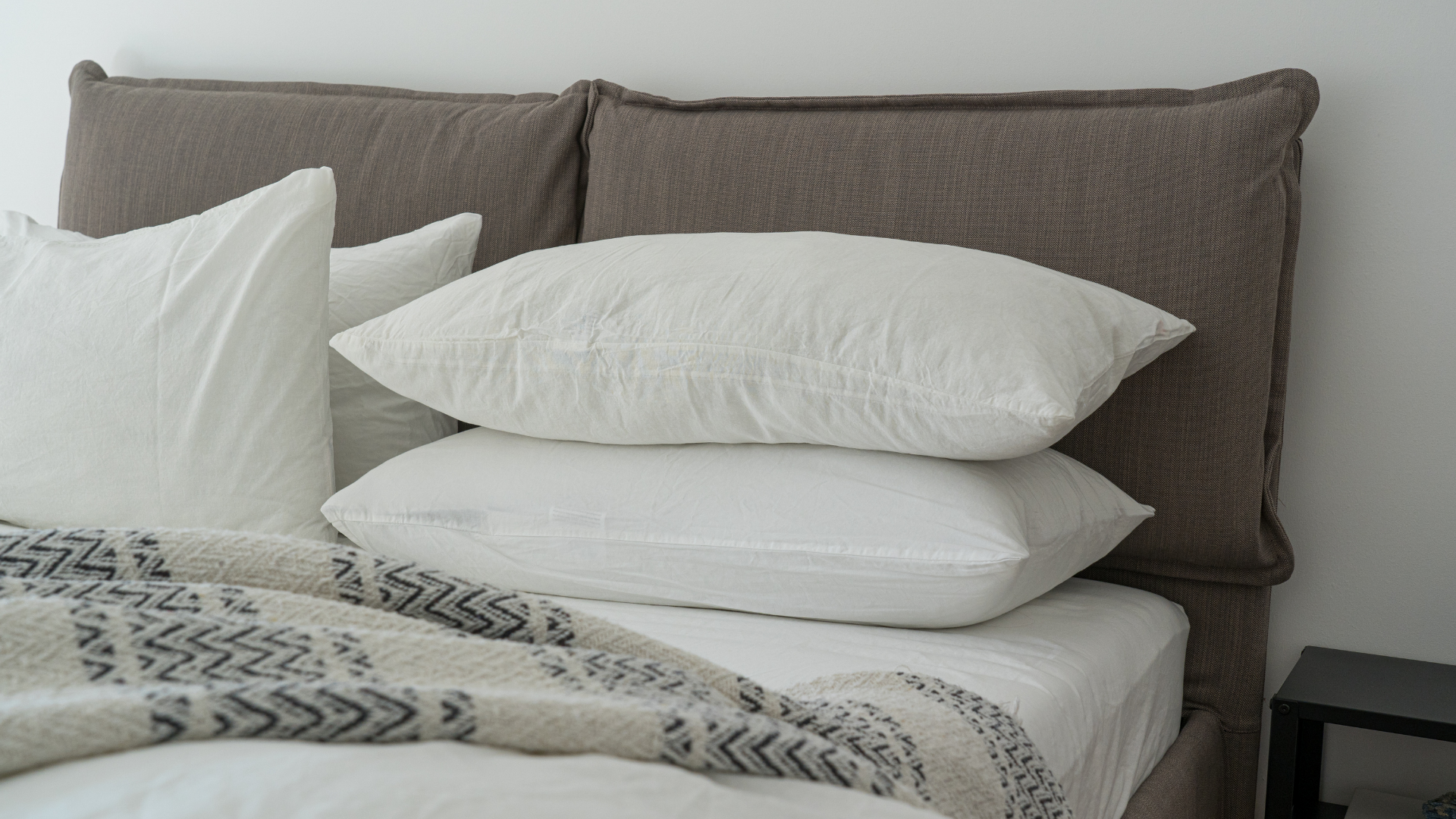 A bed with a blanket and pillows on it.
