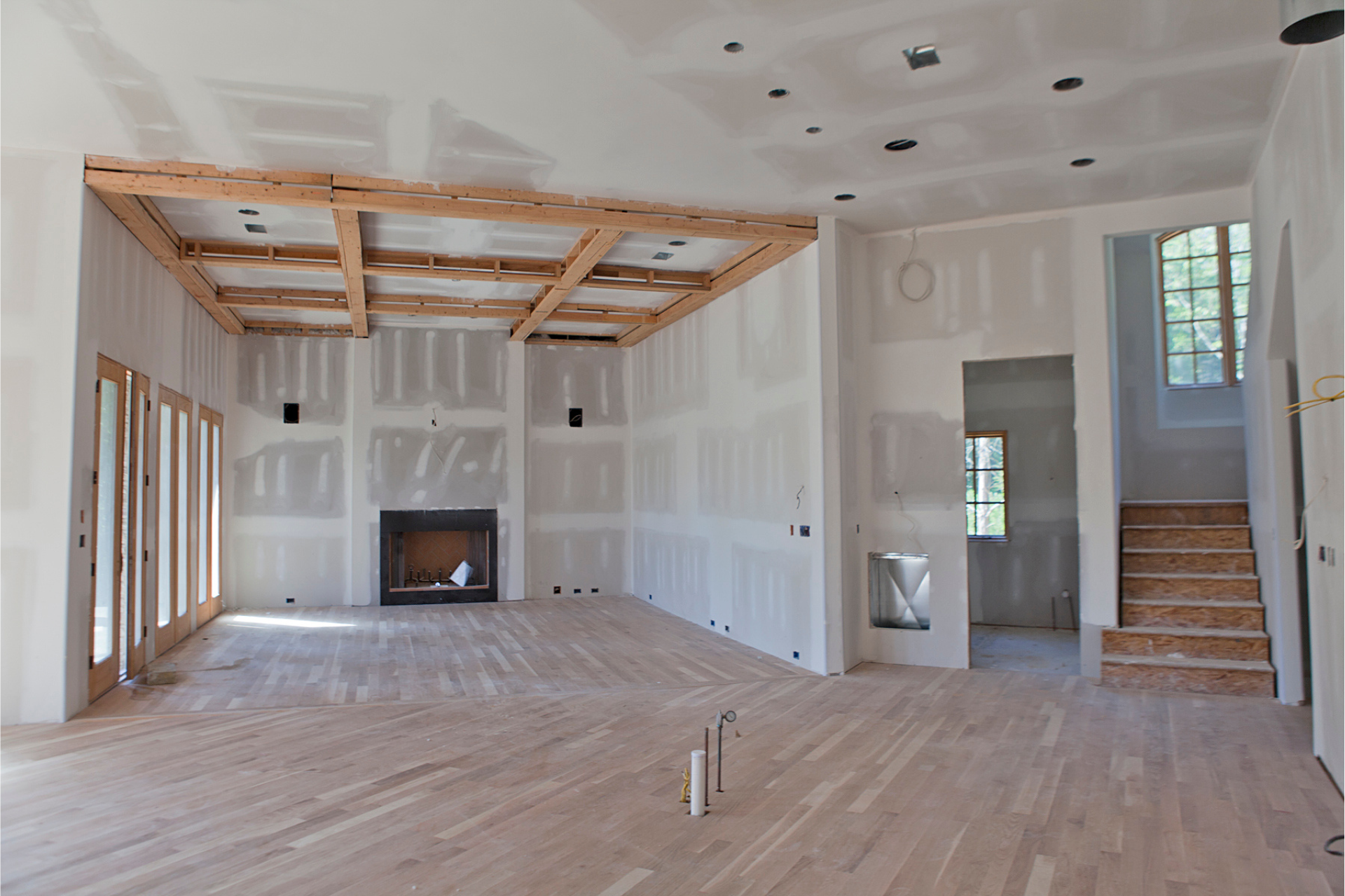 A large empty room with a fireplace and stairs