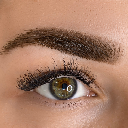 A close up of a woman 's eye with long eyelashes.