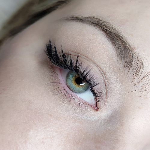 A close up of a woman 's eye with long eyelashes.