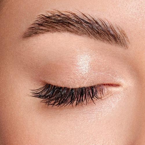 A close up of a woman 's eye with long eyelashes.