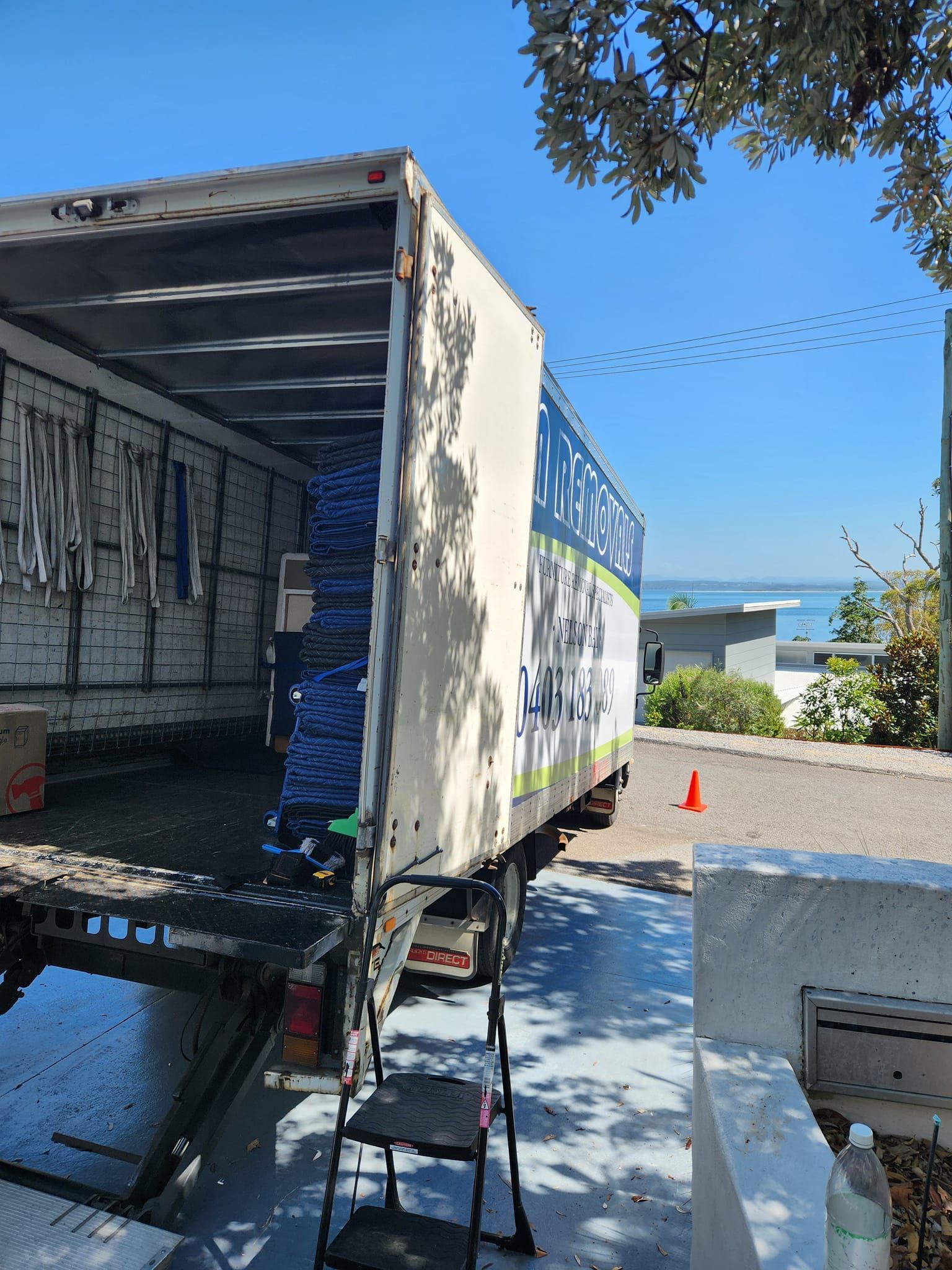 Moving Truck Backed Into a Driveway Beside a House — MM Removals In Nelson Bay, NSW