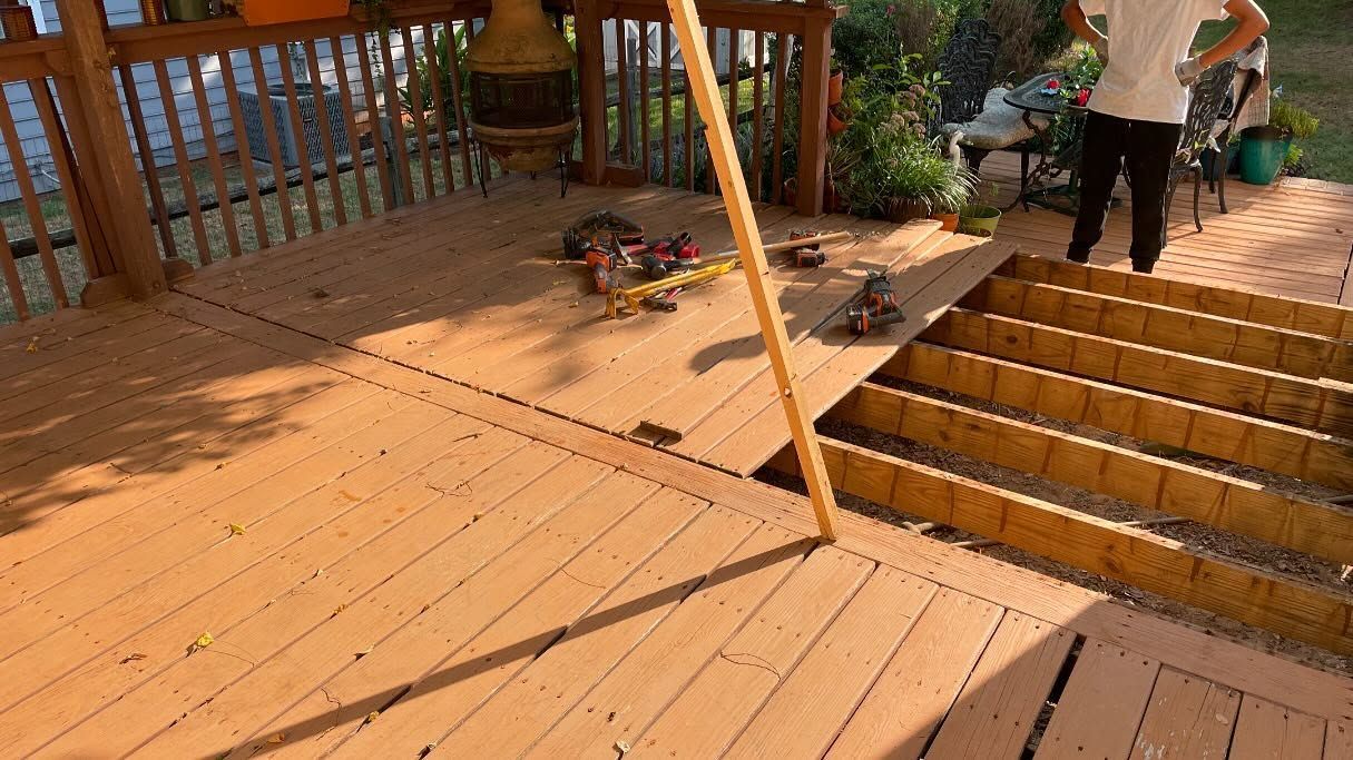 Person on deck with some boards removed, preparing to install new ones.
