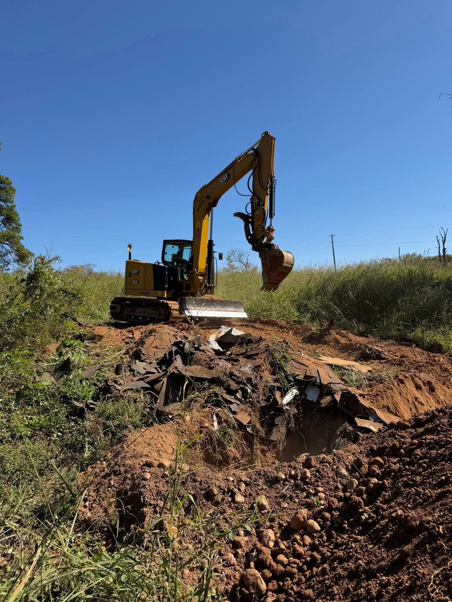 Yellow excavator digging earth on a sunny day.