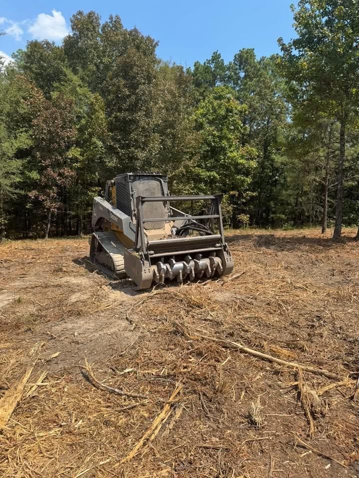 Bobcat forestry mulcher clearing debris in a wooded area on a sunny day.