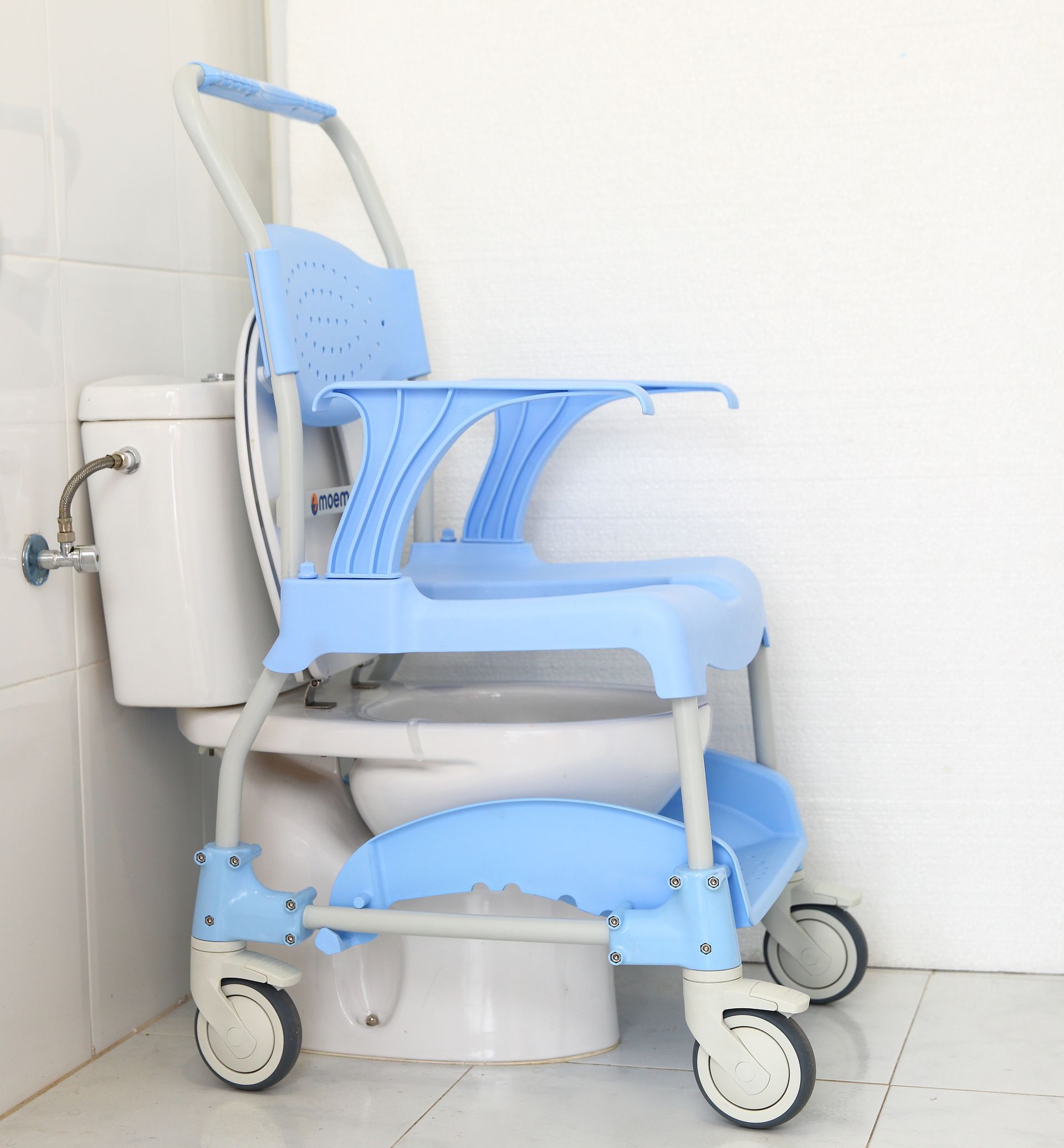 Silla inodoro azul colocada sobre un inodoro en un baño blanco.
