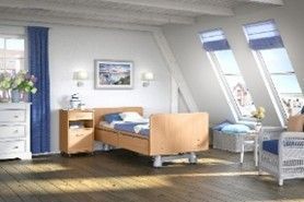 Dormitorio con cama de hospital, tragaluces, tocador, mesita de noche y detalles en azul.