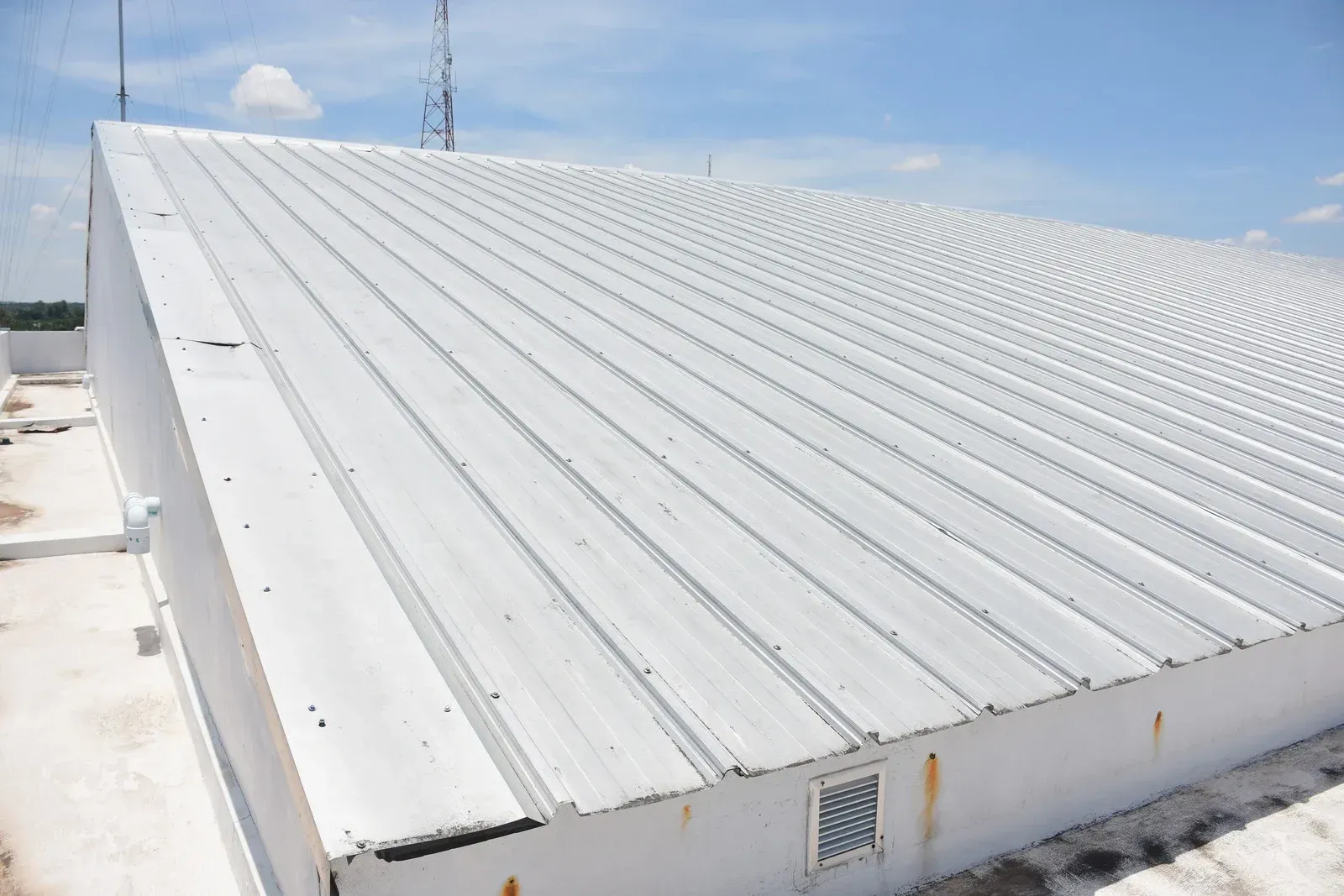 Snow-covered metal roof under a clear blue sky