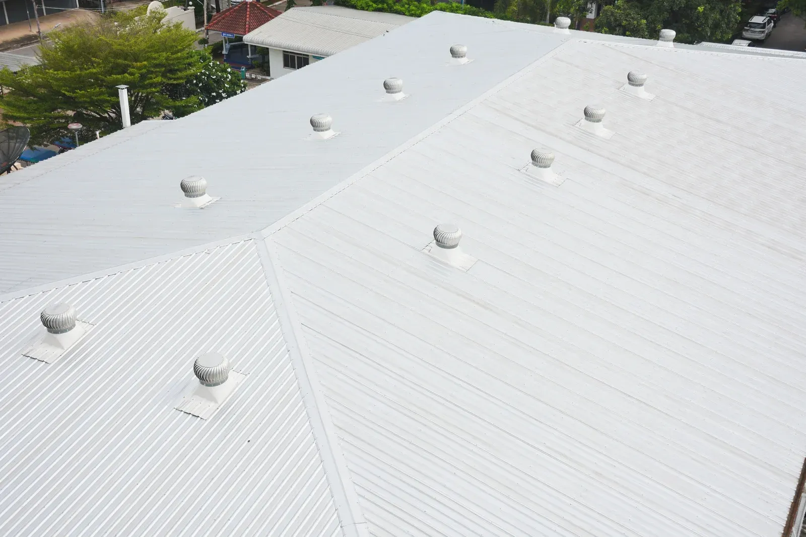 White metal roof with multiple vents on a building viewed from above
