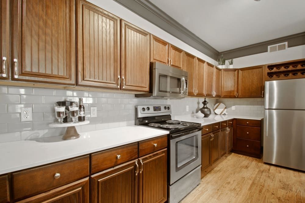 a kitchen with stainless steel appliances and wooden cabinets at Marquis on Evans in San Antonio, TX.